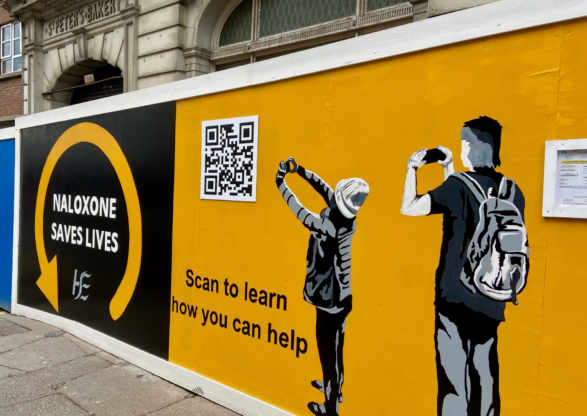 An HSE Mural saying Naloxone saves lives with a QR code and two painted people scanning it