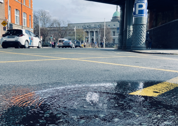 water bubbling up on a street through a grate