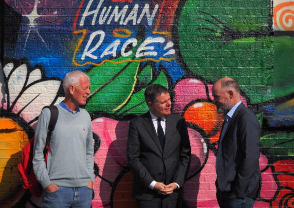 CASPr staff standing in front of a colorful wall with the words the Human Race