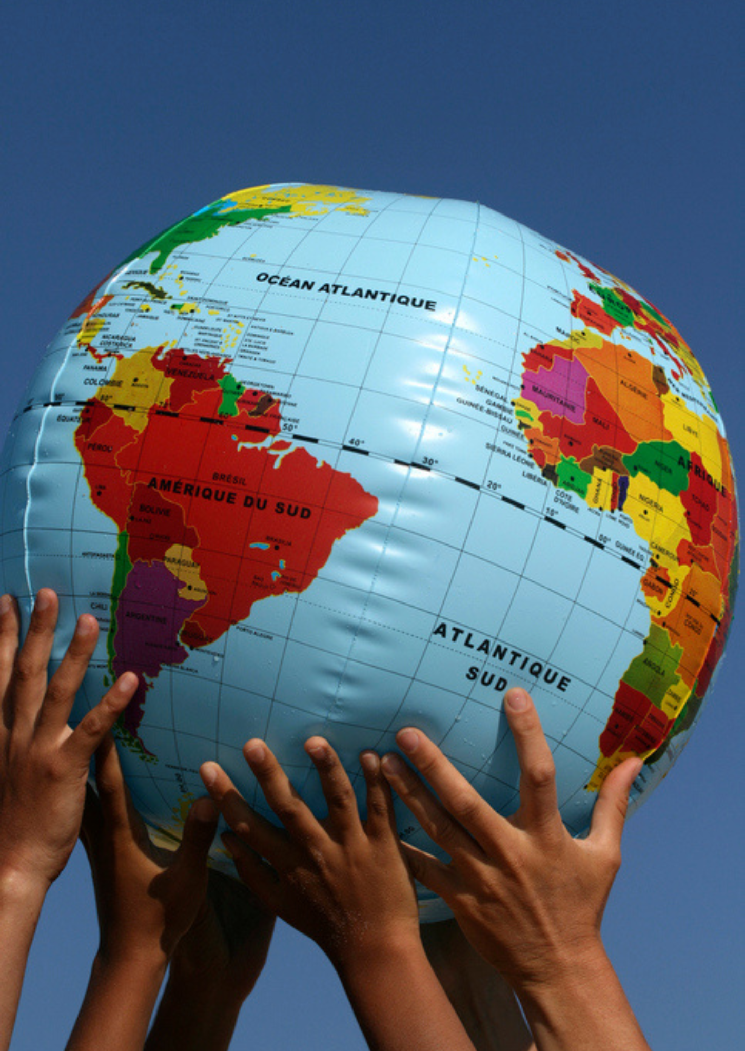 3 sets of hands holding up an inflatable globe