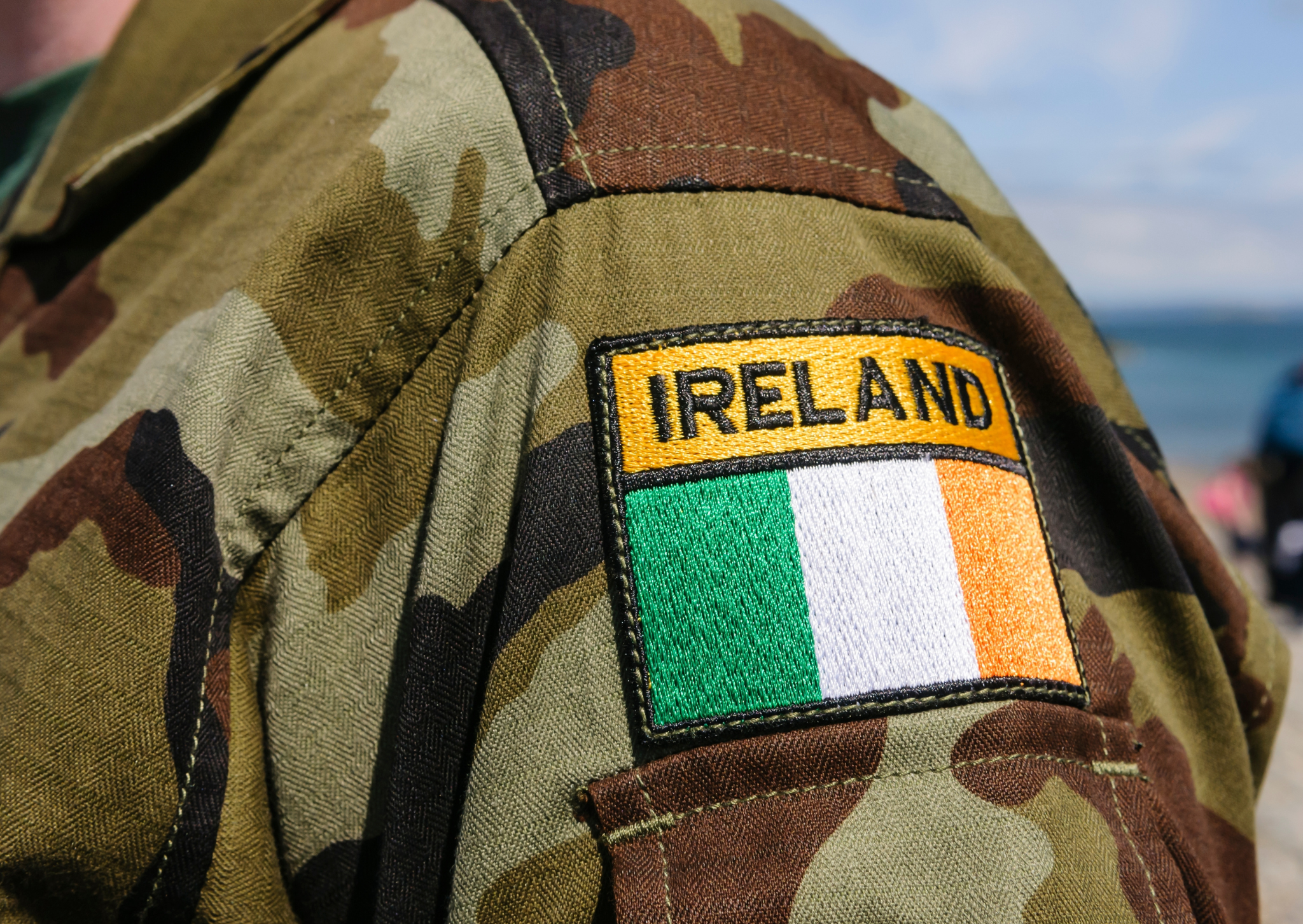 the arm of an Irish soldier with the Irish flag on their shoulder